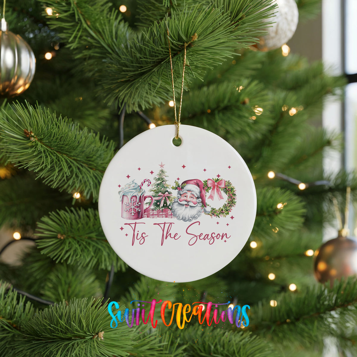 Round ceramic Christmas ornament featuring vintage Santa with floral greenery and ’Tis the Season lettering, hanging on a green Christmas tree