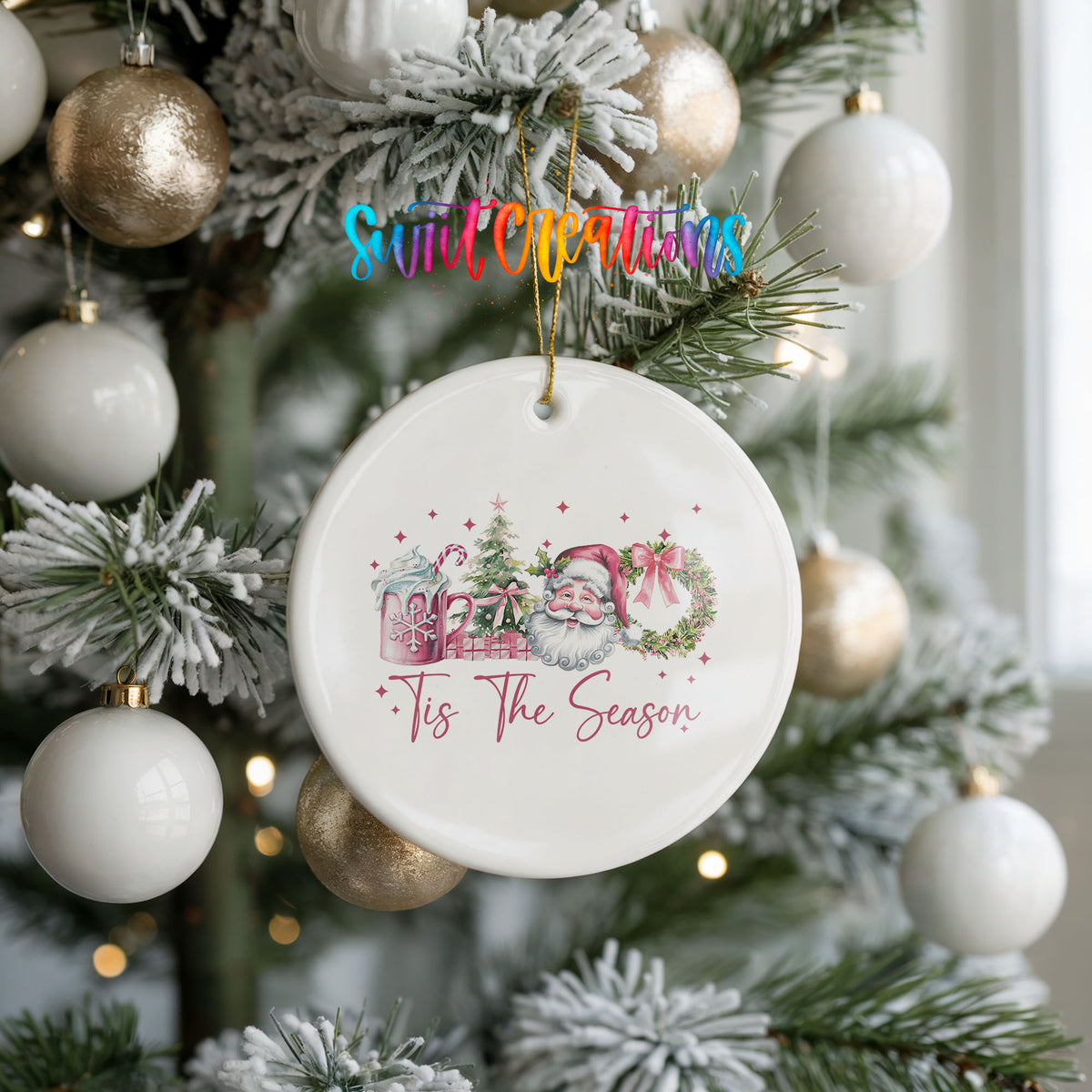 Round ceramic Christmas ornament featuring vintage Santa with floral greenery and ’Tis the Season lettering, hanging on a frosted holiday tree