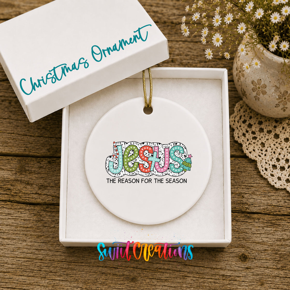 Round ceramic Christmas ornament featuring colorful Jesus Is the Reason for the Season typography, displayed in the included gift box