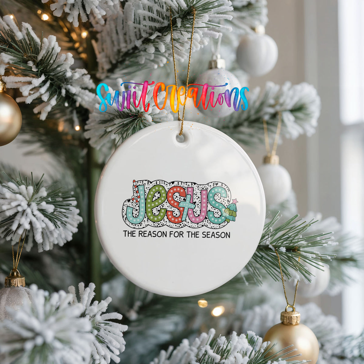 Round ceramic Christmas ornament featuring colorful Jesus Is the Reason for the Season typography, hanging on a frosted Christmas tree