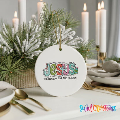 Round ceramic Christmas ornament featuring colorful Jesus Is the Reason for the Season typography, styled with elegant holiday table decor