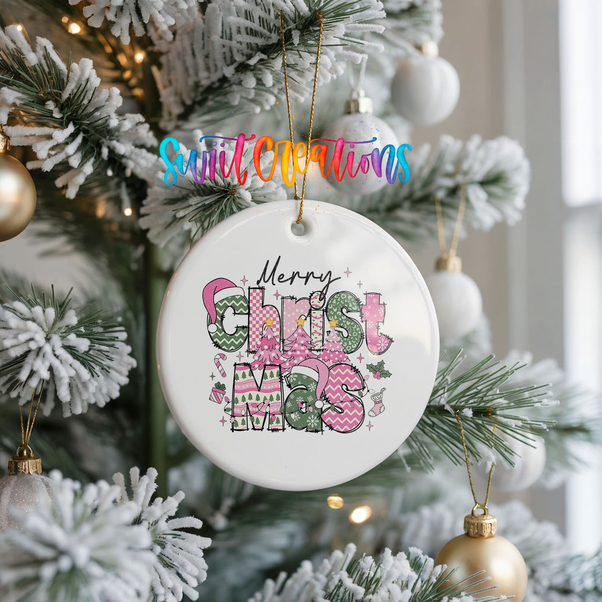 Round ceramic Christmas ornament featuring stacked patterned Merry Christmas lettering in pink green and black, hanging on a frosted Christmas tree