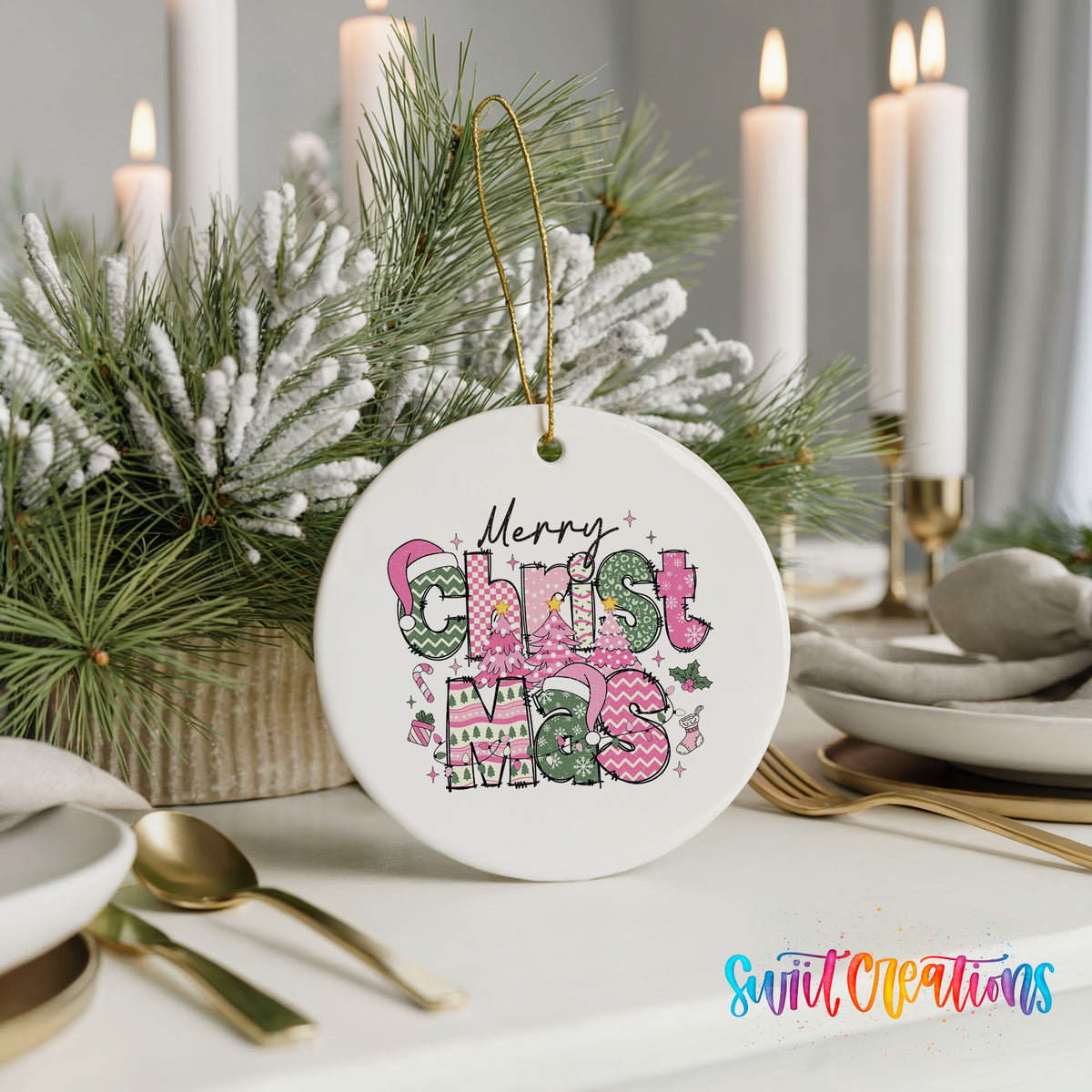 Round ceramic Christmas ornament featuring stacked patterned Merry Christmas lettering in pink green and black, styled with elegant holiday table decor