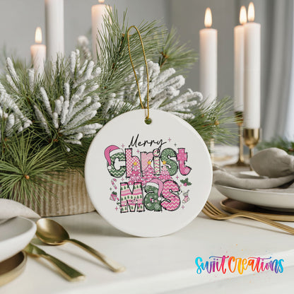 Round ceramic Christmas ornament featuring stacked patterned Merry Christmas lettering in pink green and black, styled with elegant holiday table decor