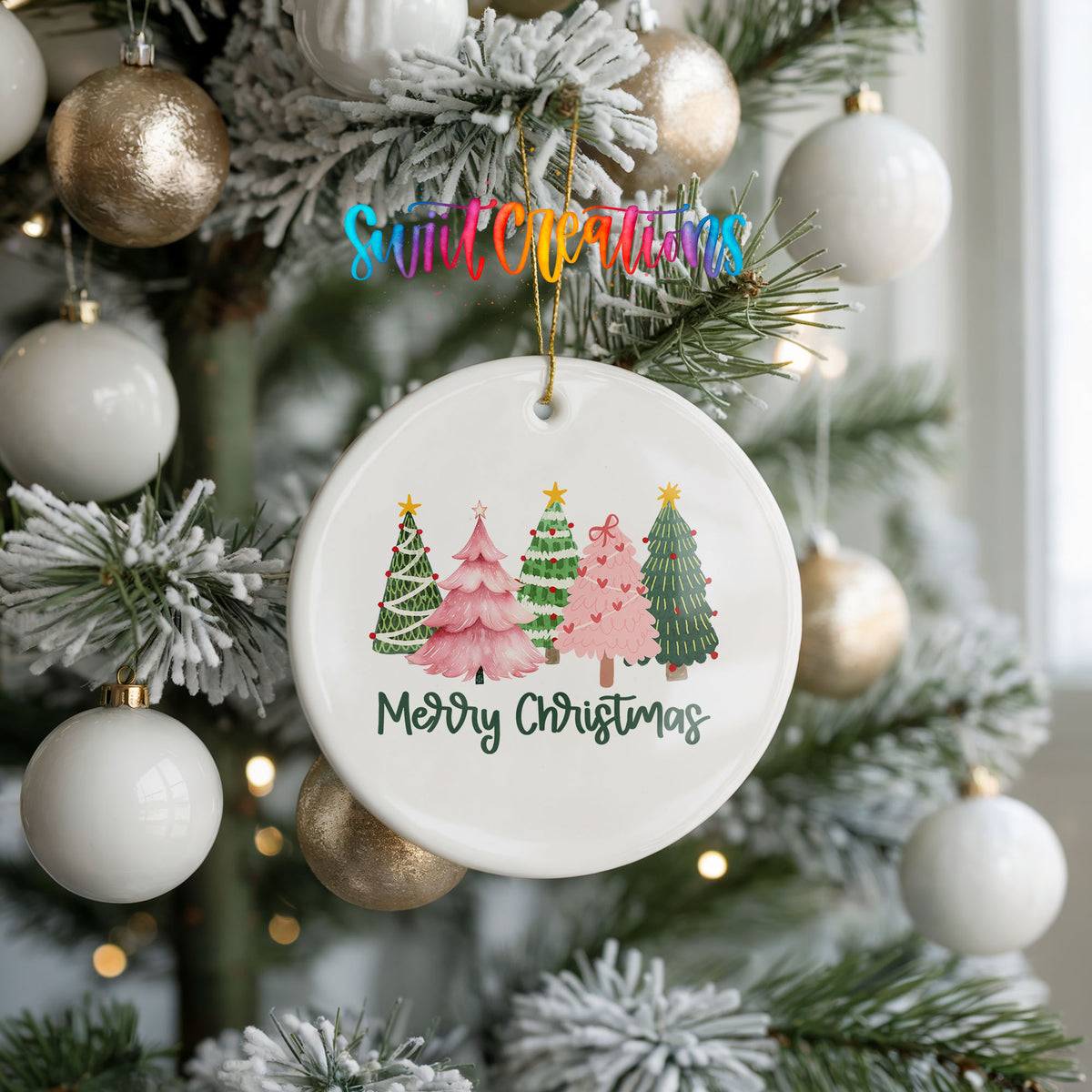 Round ceramic Christmas ornament featuring row of whimsical colorful Christmas trees with Merry Christmas script, hanging on a frosted holiday tree