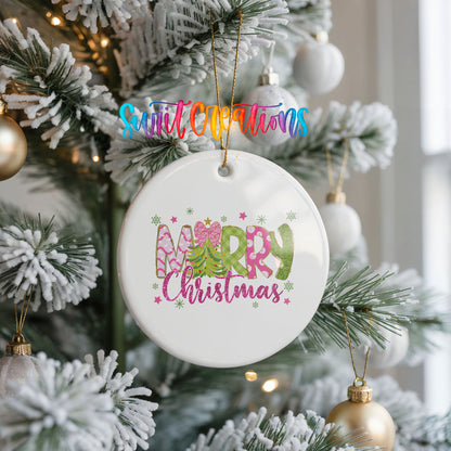 Round ceramic Christmas ornament featuring bright Merry Christmas lettering with candy stripe and floral details, hanging on a frosted Christmas tree
