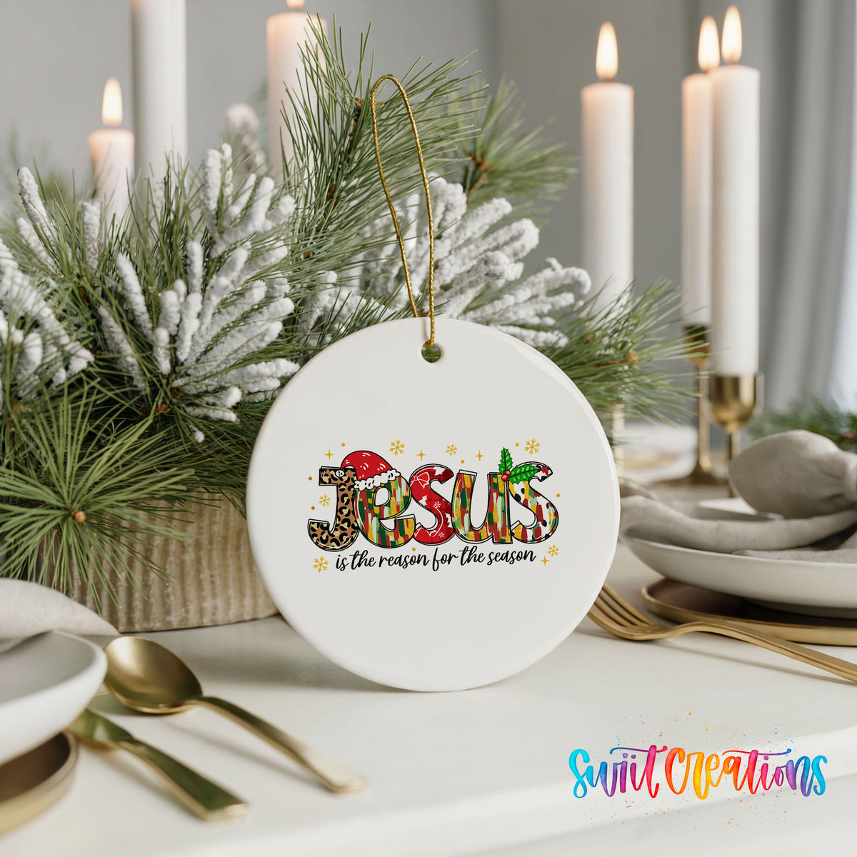 Round ceramic Christmas ornament featuring colorful Jesus Is the Reason for the Season typography, styled with elegant holiday table decor