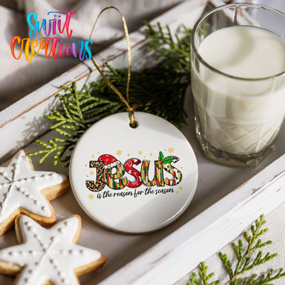 Round ceramic Christmas ornament featuring colorful Jesus Is the Reason for the Season typography, styled with cookies and milk