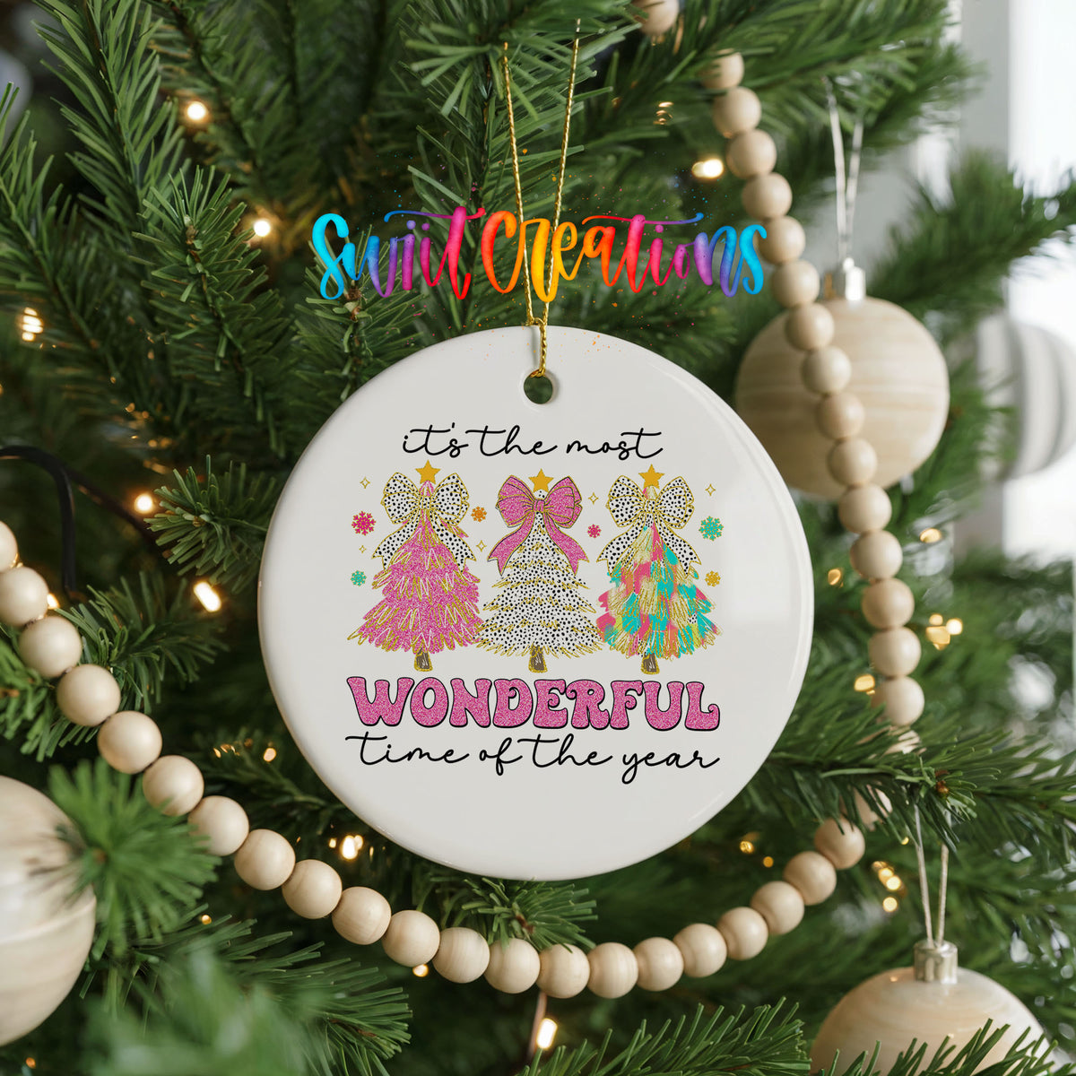 Round ceramic Christmas ornament featuring It’s the Most Wonderful Time of the Year lettering with colorful gifts and trees, hanging on a decorated Christmas tree