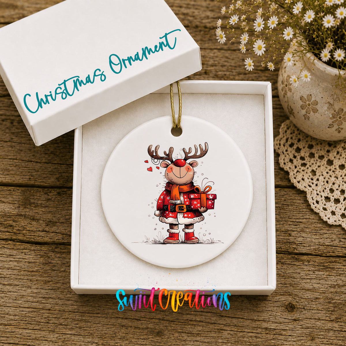 Round ceramic Christmas ornament featuring cheerful reindeer in a Santa suit holding wrapped Christmas gifts, displayed in the included gift box