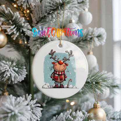 Round ceramic Christmas ornament featuring smiling reindeer in red plaid winter clothes against a snowy blue background, hanging on a frosted Christmas tree