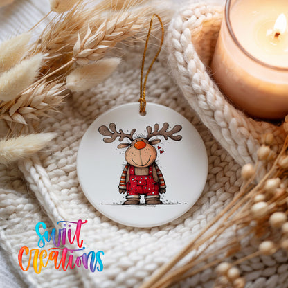 Reindeer Girl in Red Plaid Dress Christmas ornament styled beside a candle and cozy knit blanket
