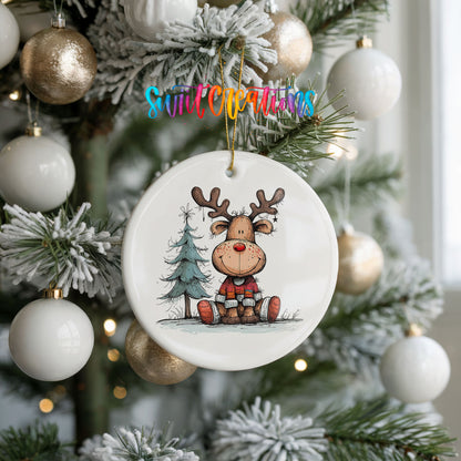 Sitting Reindeer with Pine Trees and Gift Christmas ornament hanging on a frosted holiday tree