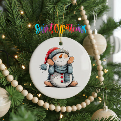 Snowman in Blue Hat and Scarf Christmas ornament hanging on a decorated Christmas tree