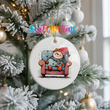 Santa Resting in a Holiday Armchair Christmas ornament hanging on a frosted Christmas tree