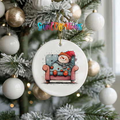Santa Resting in a Holiday Armchair Christmas ornament hanging on a frosted holiday tree