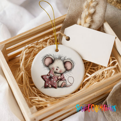 pink mouse holding a star ceramic Christmas ornament displayed in a wooden gift crate