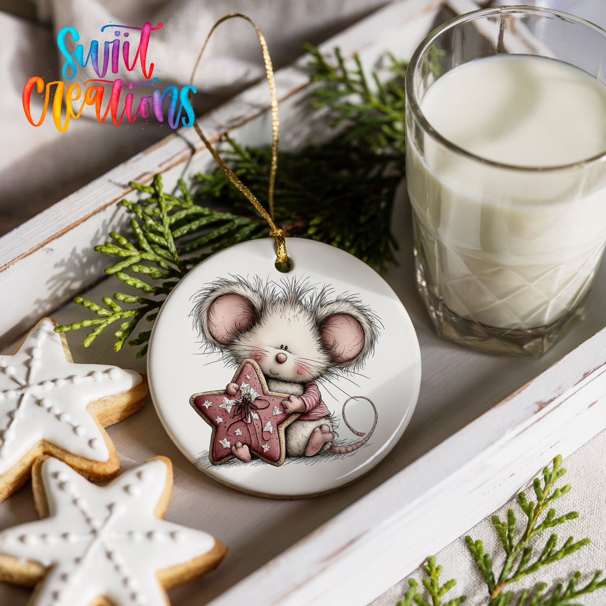 pink mouse holding a star ceramic Christmas ornament styled with holiday cookies and a candle