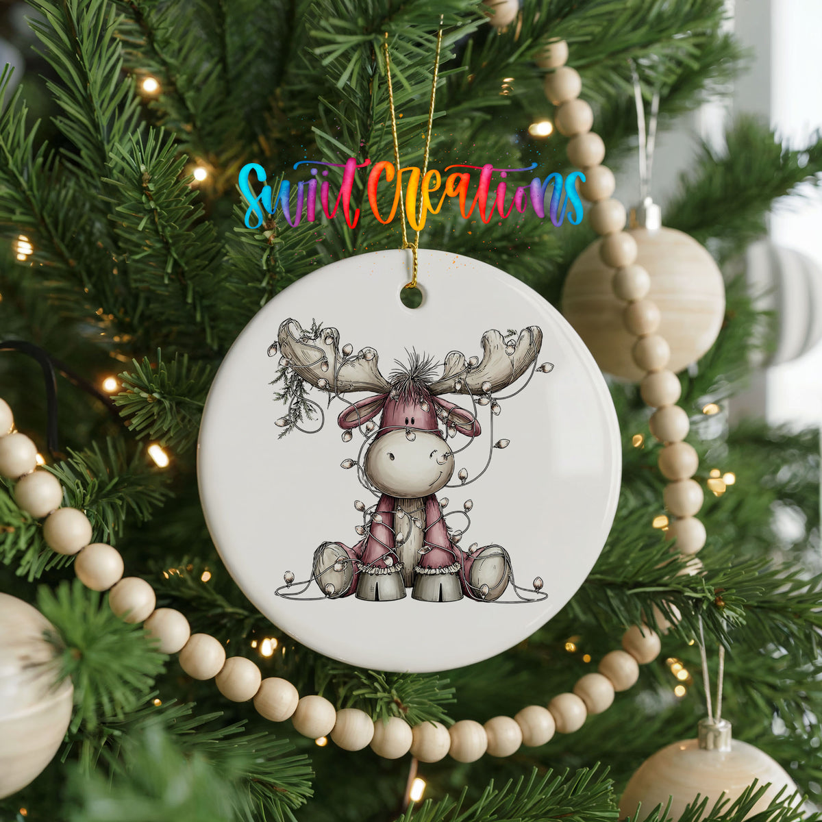 pink reindeer wrapped in Christmas lights ceramic Christmas ornament hanging on a green Christmas tree