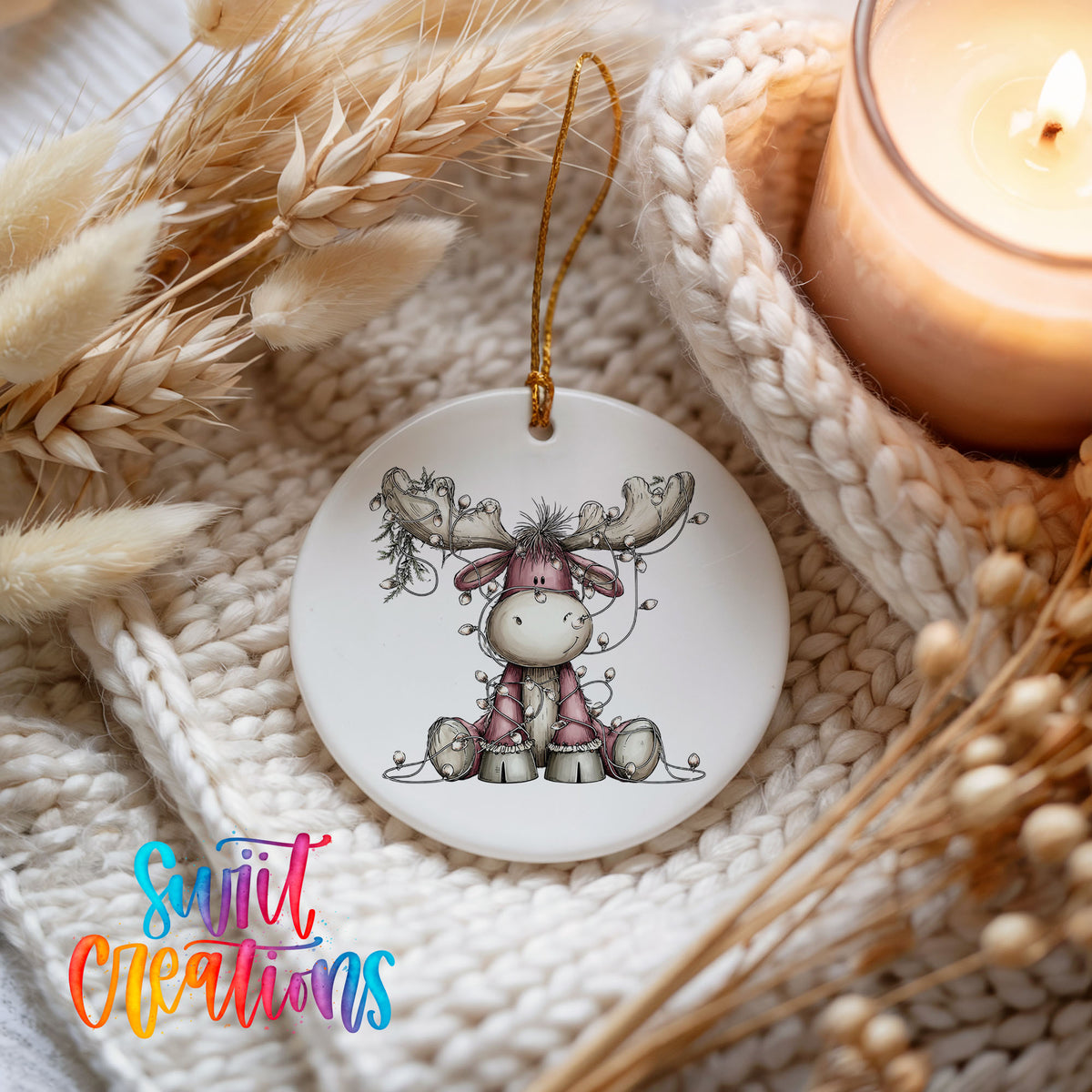 pink reindeer wrapped in Christmas lights ceramic Christmas ornament styled on a cozy knit blanket