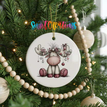 pink reindeer with decorated antlers ceramic Christmas ornament hanging on a green Christmas tree