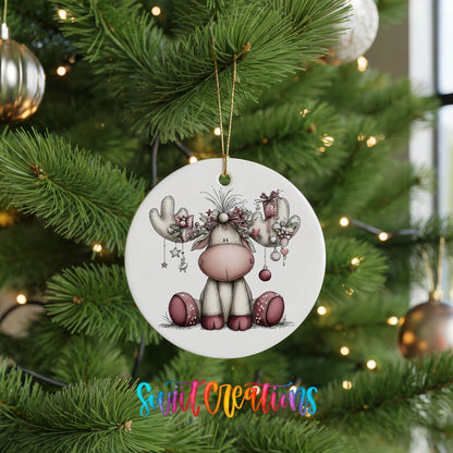 pink reindeer with decorated antlers ceramic Christmas ornament hanging on a lit Christmas tree