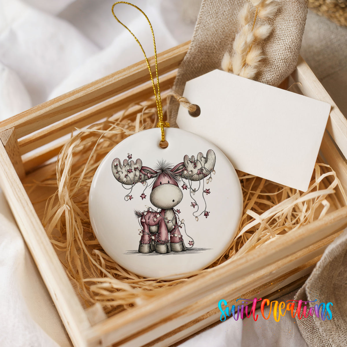 pink reindeer with hanging ornaments ceramic Christmas ornament displayed in a wooden gift crate
