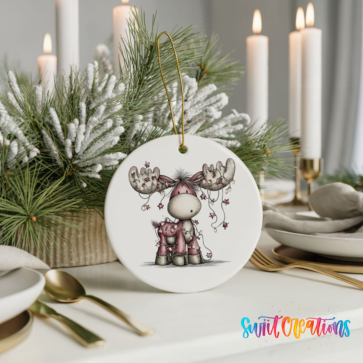 pink reindeer with hanging ornaments ceramic Christmas ornament shown in a holiday table setting