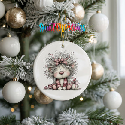 white and pink kitten in a floral winter headpiece ceramic Christmas ornament hanging on a frosted tree with ornaments