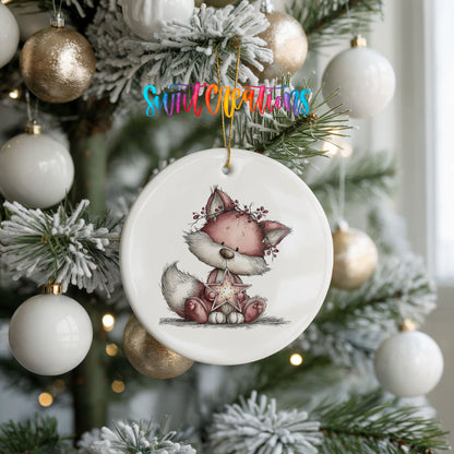 pink fox in a winter scarf ceramic Christmas ornament hanging on a frosted tree with ornaments