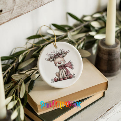 pink reindeer in a scarf with a berry antler crown ceramic Christmas ornament styled on stacked books with greenery