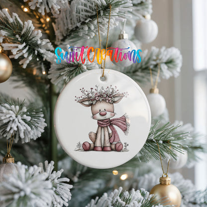 pink reindeer in a scarf with a berry antler crown ceramic Christmas ornament hanging on a frosted Christmas tree