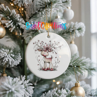 pink reindeer with snowy floral antlers ceramic Christmas ornament hanging on a frosted Christmas tree