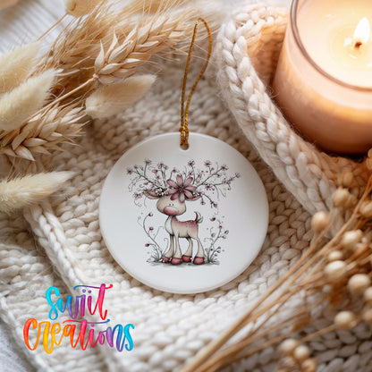 pink reindeer with snowy floral antlers ceramic Christmas ornament styled on a cozy knit blanket