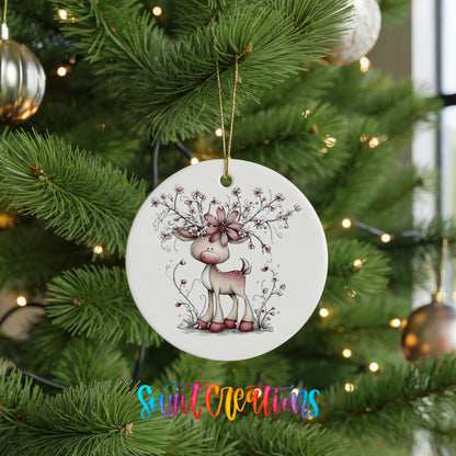 pink reindeer with snowy floral antlers ceramic Christmas ornament hanging on a lit Christmas tree