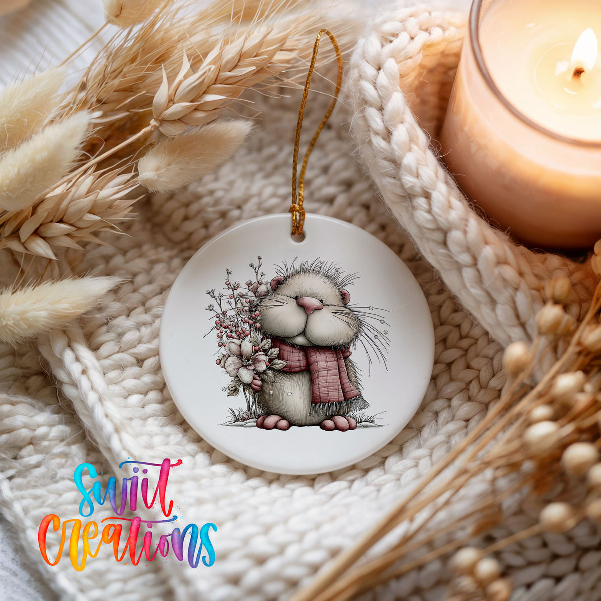 fluffy mouse in a pink scarf with flowers and berries ceramic Christmas ornament styled on a cozy knit blanket