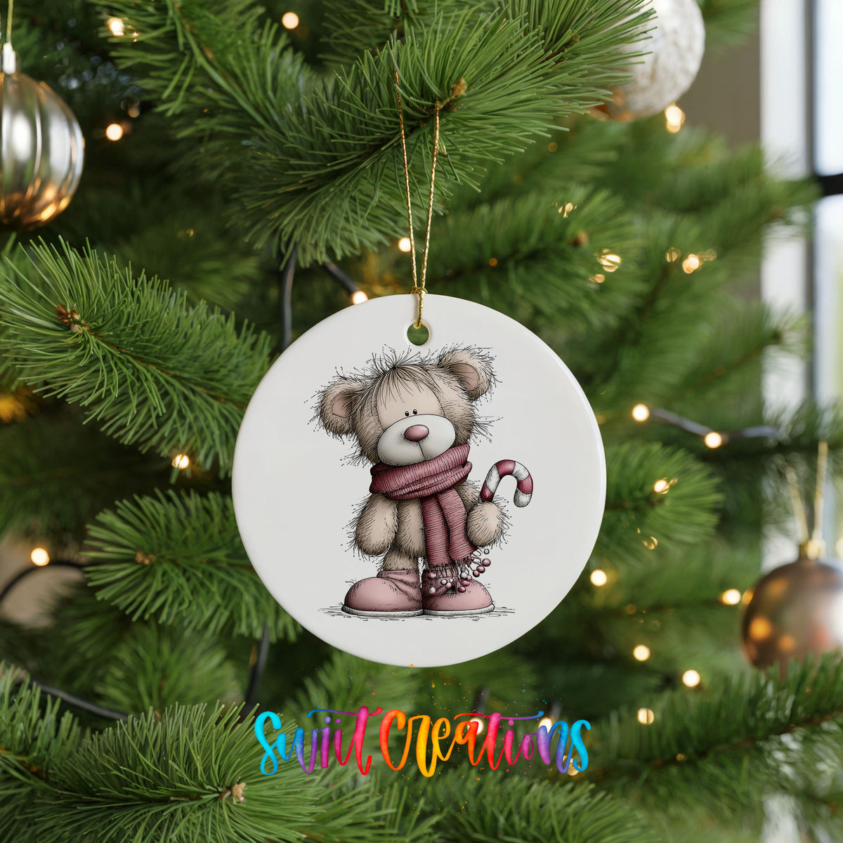 teddy bear in a pink scarf holding a candy cane ceramic Christmas ornament hanging on a lit Christmas tree