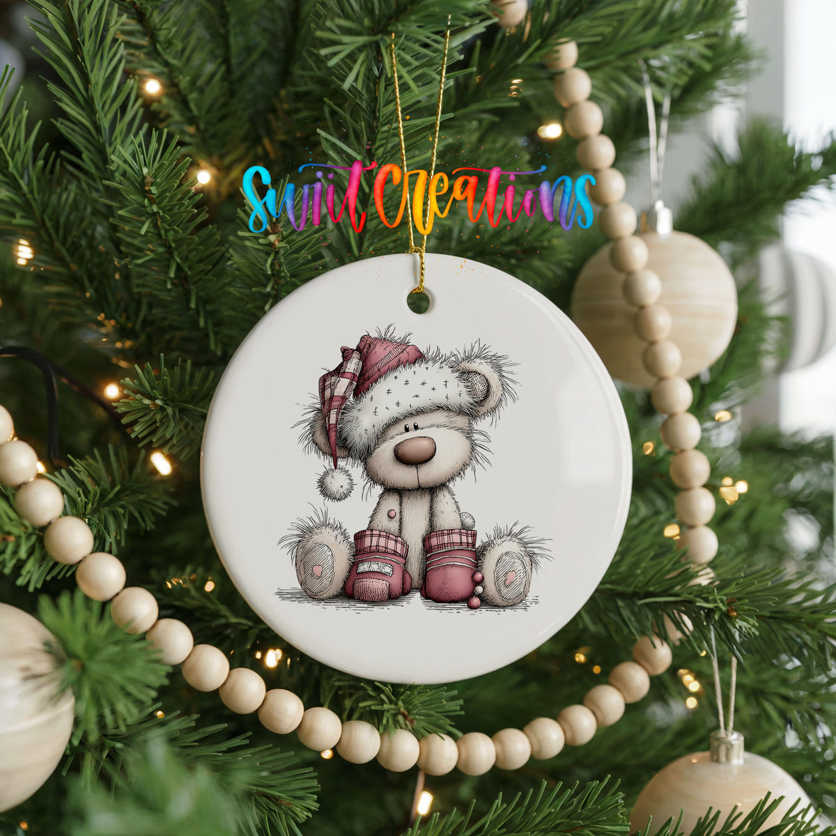 teddy bear in a Santa hat with Christmas gifts ceramic Christmas ornament hanging on a green Christmas tree