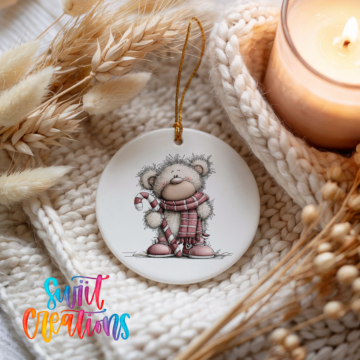 teddy bear holding a candy cane in winter clothes ceramic Christmas ornament styled on a cozy knit blanket