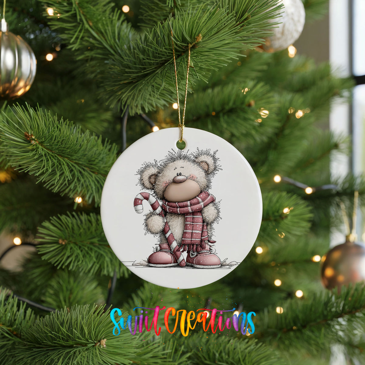 teddy bear holding a candy cane in winter clothes ceramic Christmas ornament hanging on a lit Christmas tree