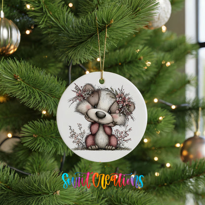 raccoon with winter flowers and greenery ceramic Christmas ornament hanging on a lit Christmas tree