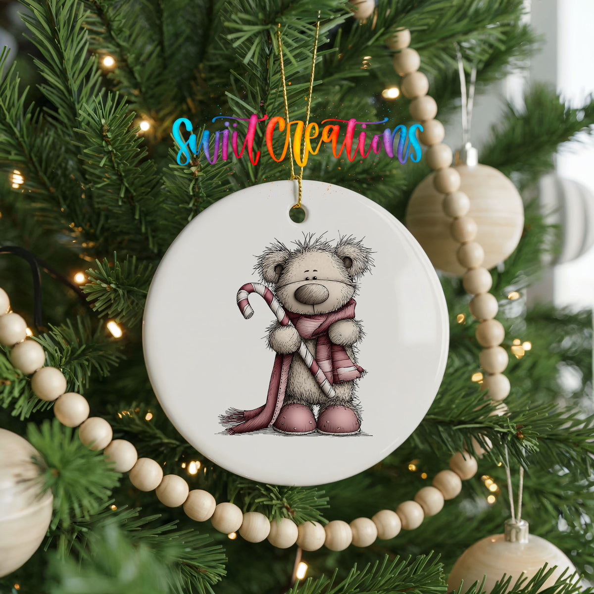teddy bear holding a candy cane with a long winter scarf ceramic Christmas ornament hanging on a green Christmas tree