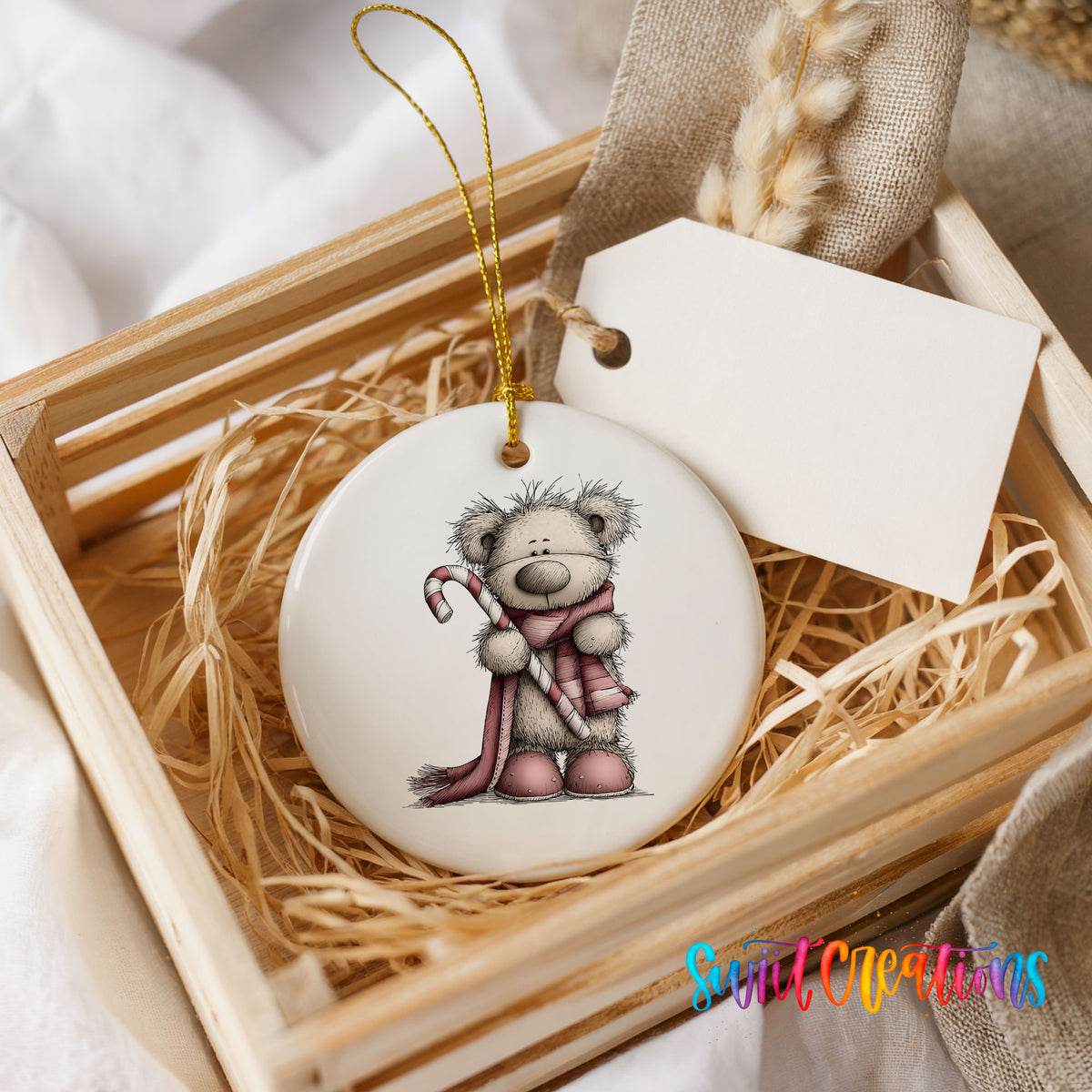 teddy bear holding a candy cane with a long winter scarf ceramic Christmas ornament displayed in a wooden gift crate