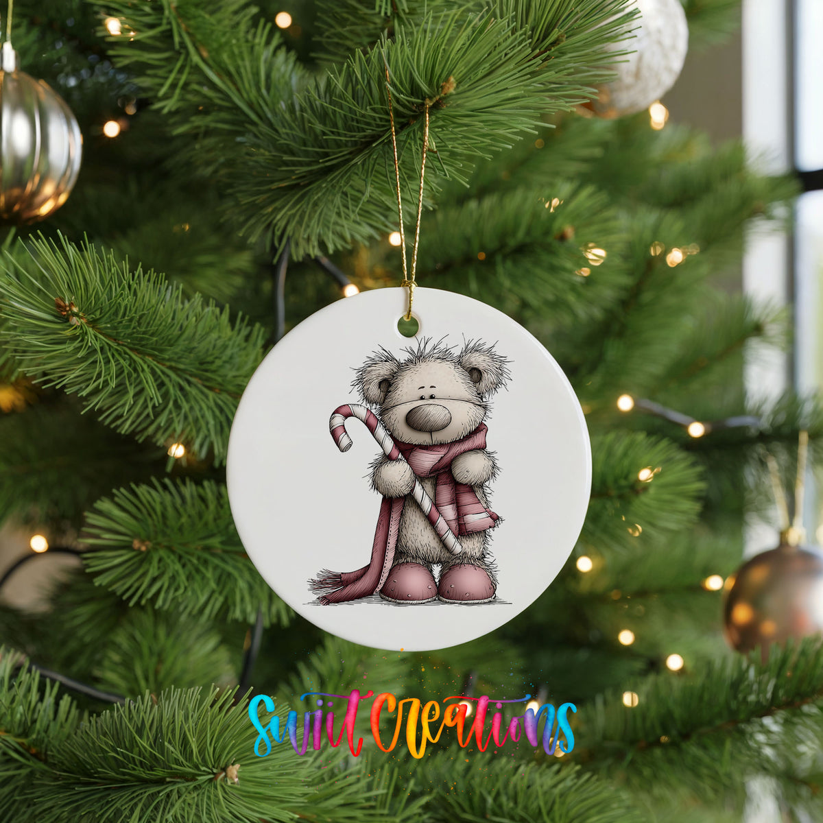 teddy bear holding a candy cane with a long winter scarf ceramic Christmas ornament hanging on a lit Christmas tree