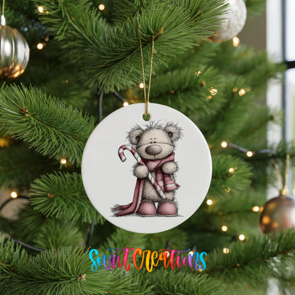 teddy bear holding a candy cane with a long winter scarf ceramic Christmas ornament hanging on a lit Christmas tree