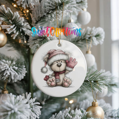 teddy bear waving beside Christmas gifts ceramic Christmas ornament hanging on a frosted Christmas tree