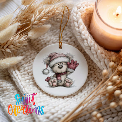 teddy bear waving beside Christmas gifts ceramic Christmas ornament styled on a cozy knit blanket