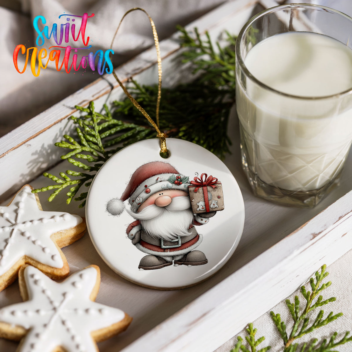 Santa Claus holding a wrapped Christmas gift ceramic Christmas ornament styled with holiday cookies and a candle