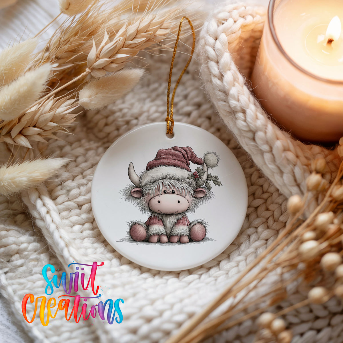 Highland cow in a pink Santa hat ceramic Christmas ornament styled on a cozy knit blanket