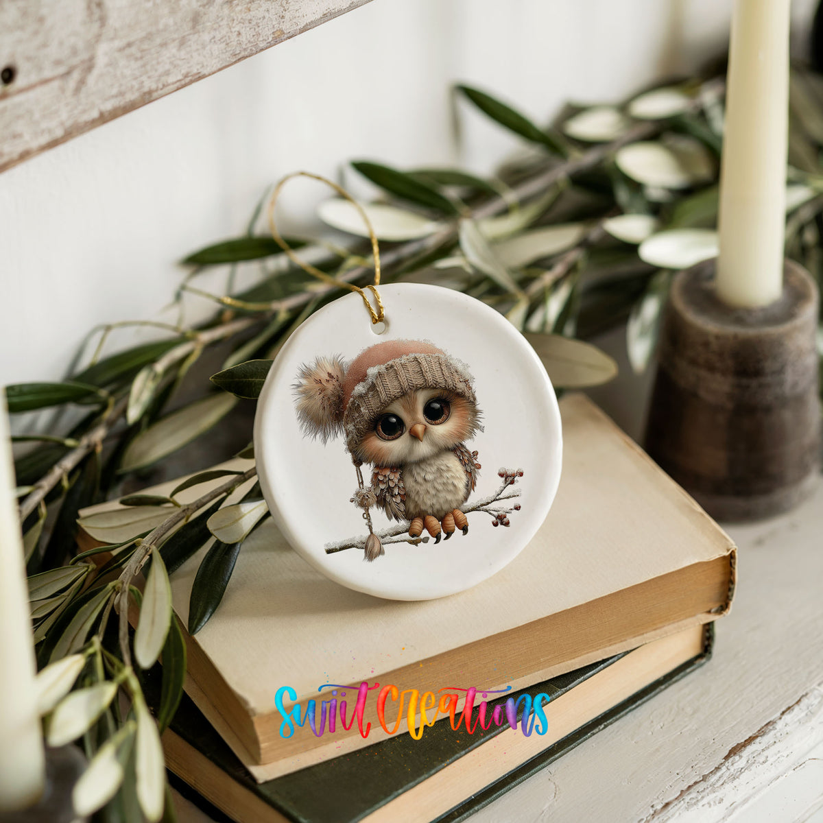winter owl perched on a snowy branch ceramic Christmas ornament styled on stacked books with greenery